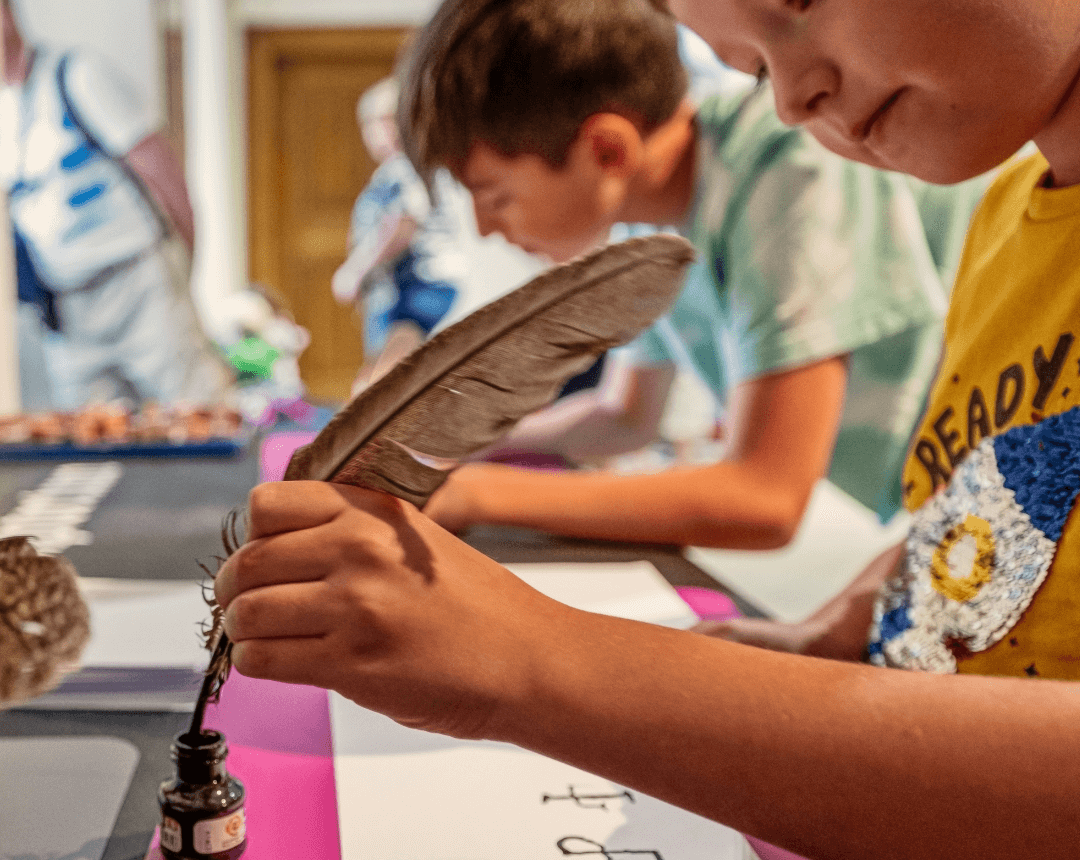 Child writing with quill pen