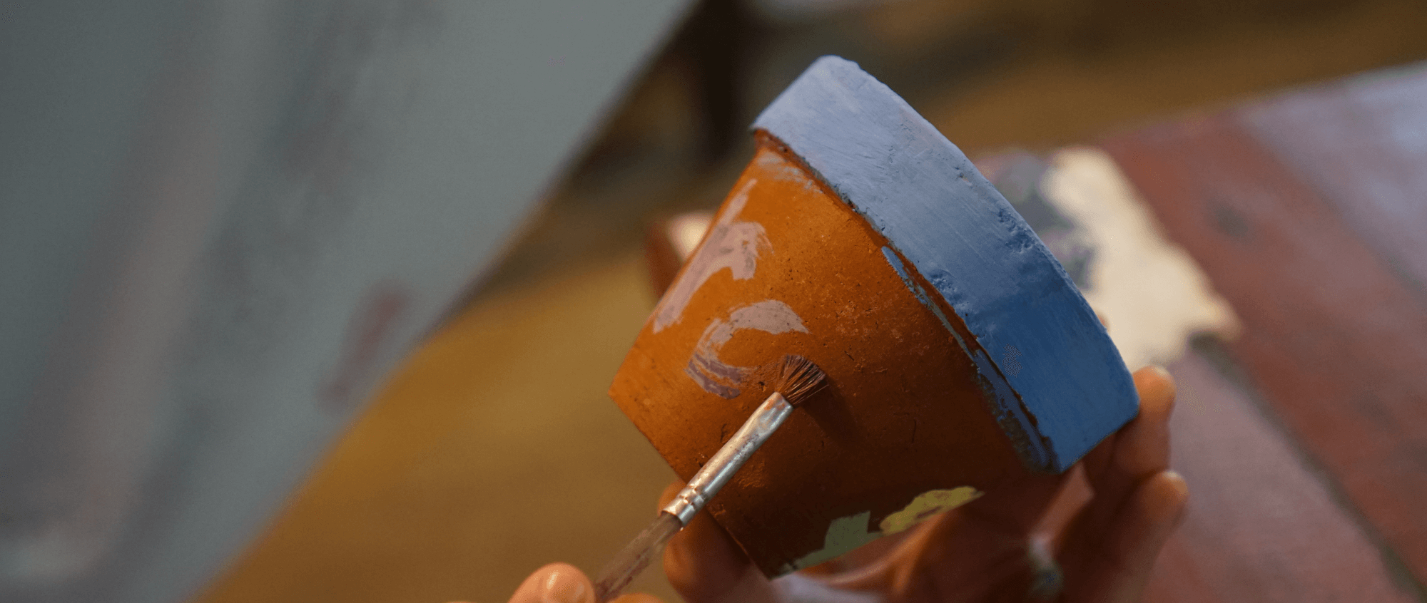 Person painting a pot