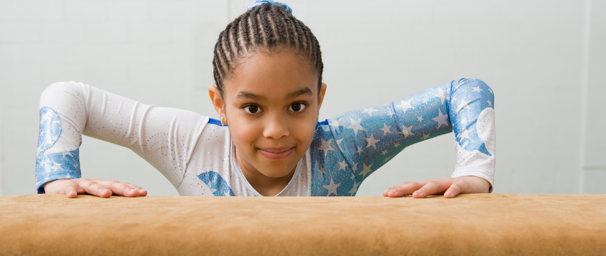 Young girl with blue outfit on a gymnastics bar