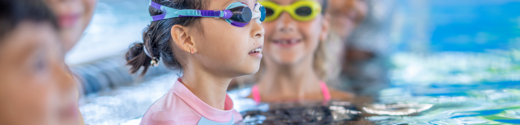 Children in swimming pool with goggles