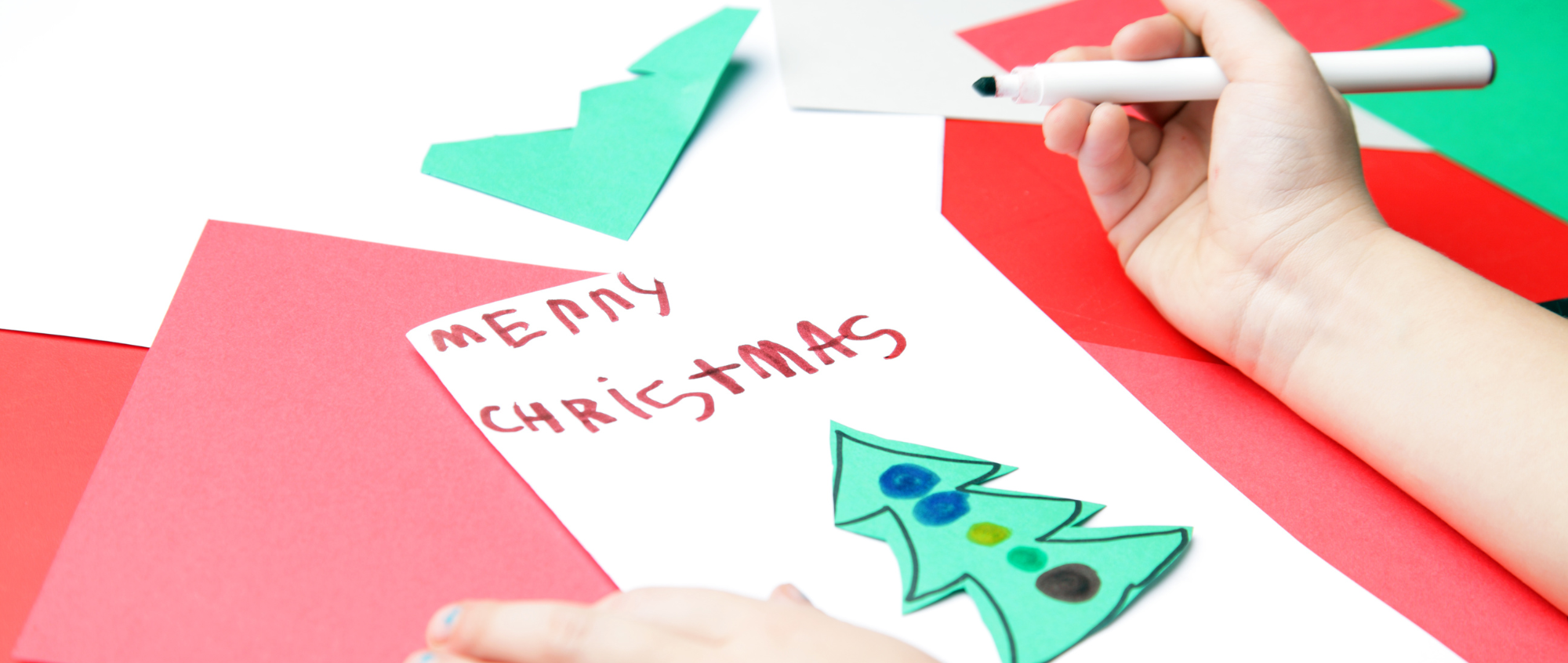 Christmas card which reads Merry Christmas with a green Christmas tree