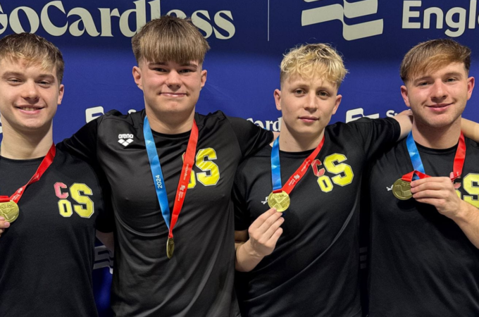 Five boys standing with various medals