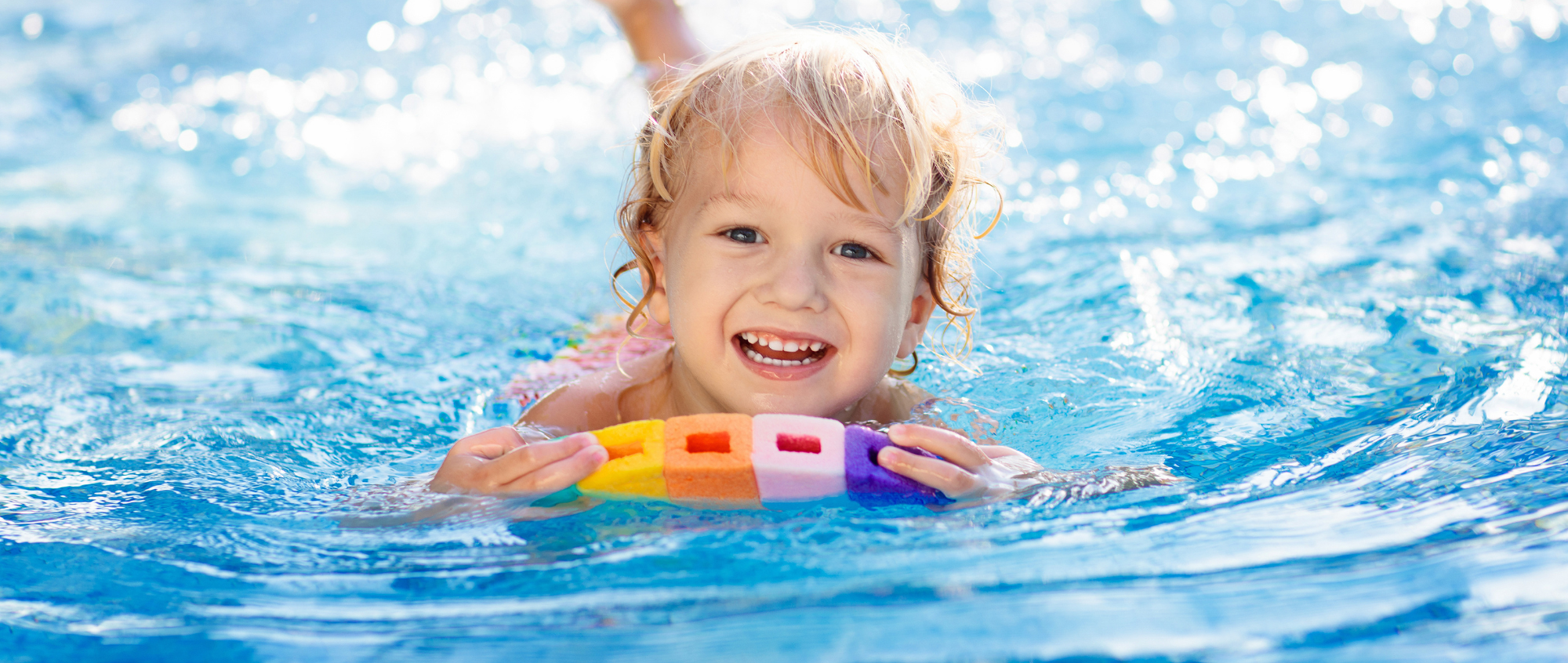 Child in swimming pool with float