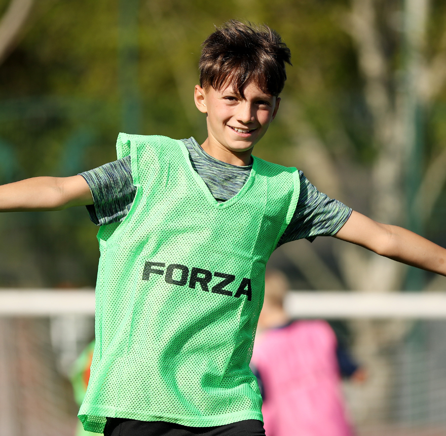 Boy with a green bib with his arms out by side
