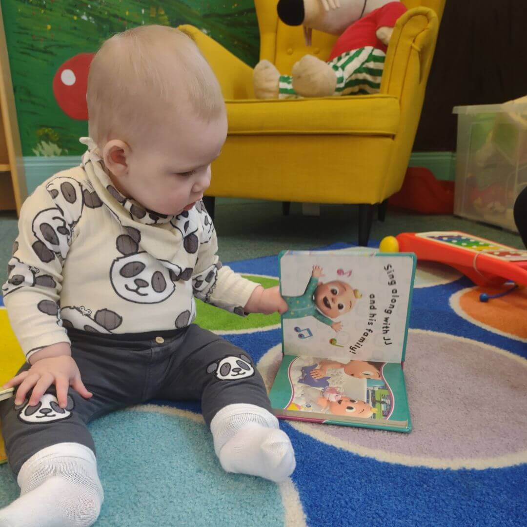 Nova interacts with a book at Winton Library