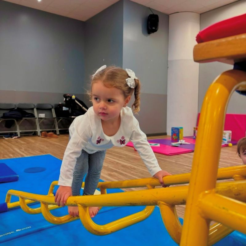 Young child climbing during baby gym at Worsley Leisure Centre
