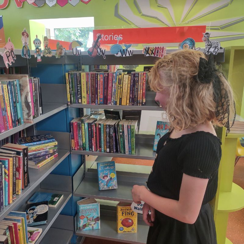 A child at the library reads a book