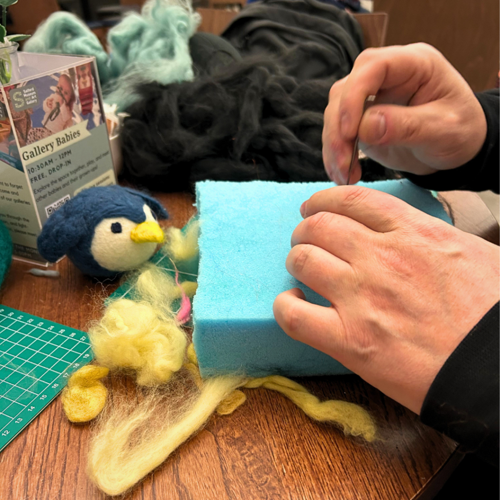 A close up of someone needle felting at SMAG Craft Social
