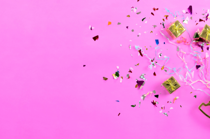 Gold trophy with confetti on a pink background