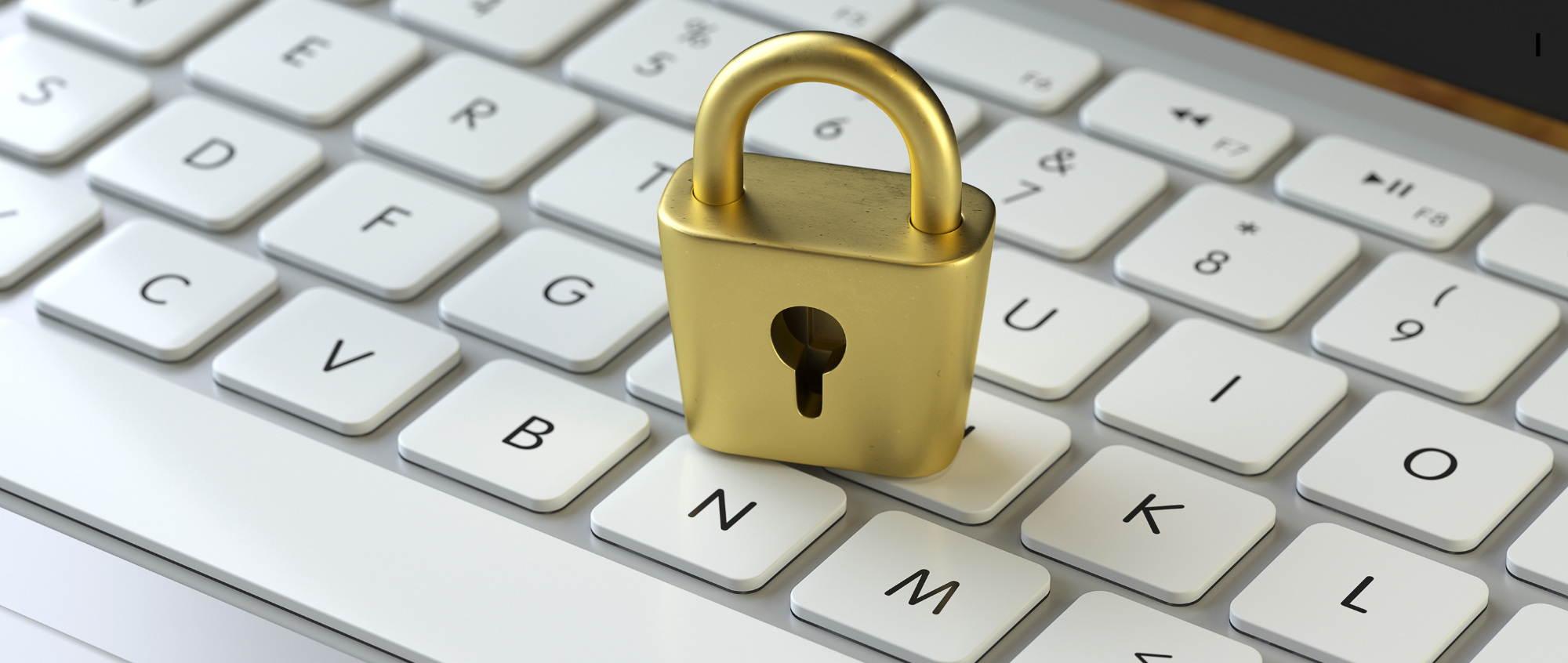 Gold padlock on white keyboard