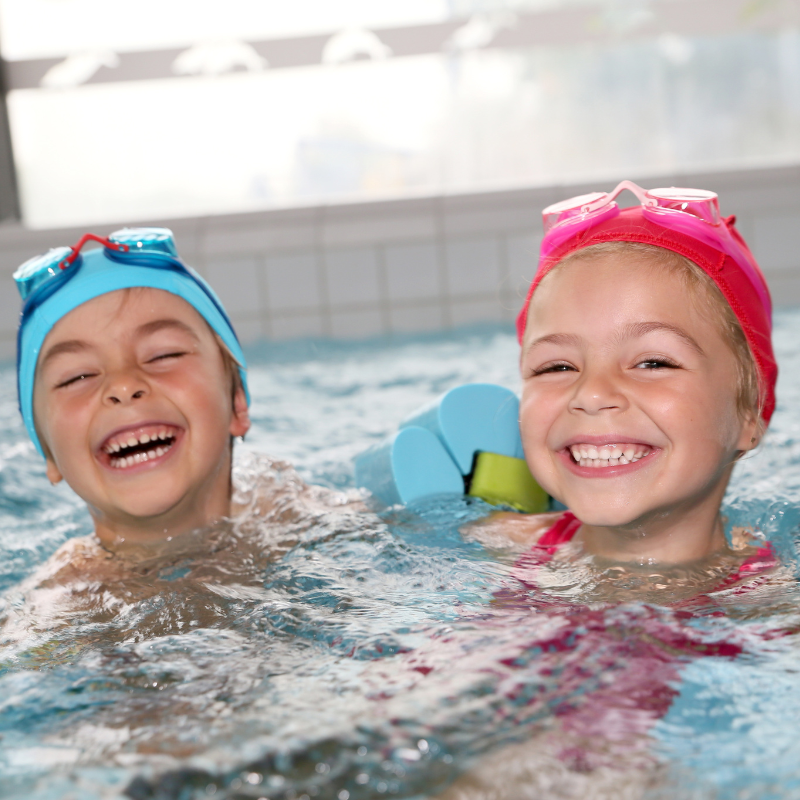 Girl and boy smiling in swimming pool
