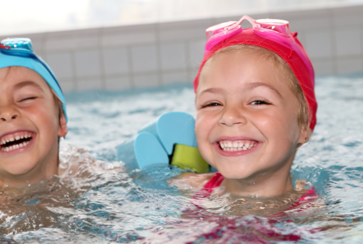 Girl and boy smiling in swimming pool