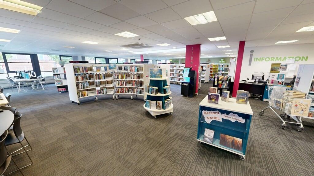 Inside Broughton Library with books and computers. Part of Salford Libraries