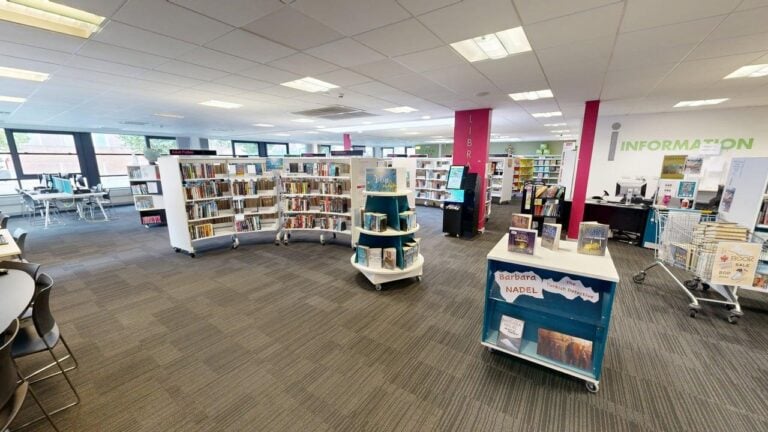 Inside Broughton Library with books and computers. Part of Salford Libraries