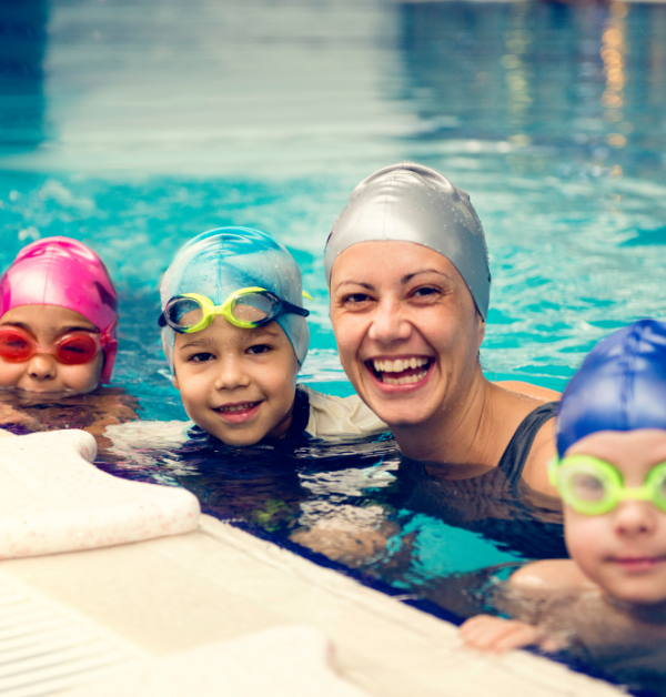 Woman and three children in swimming pool