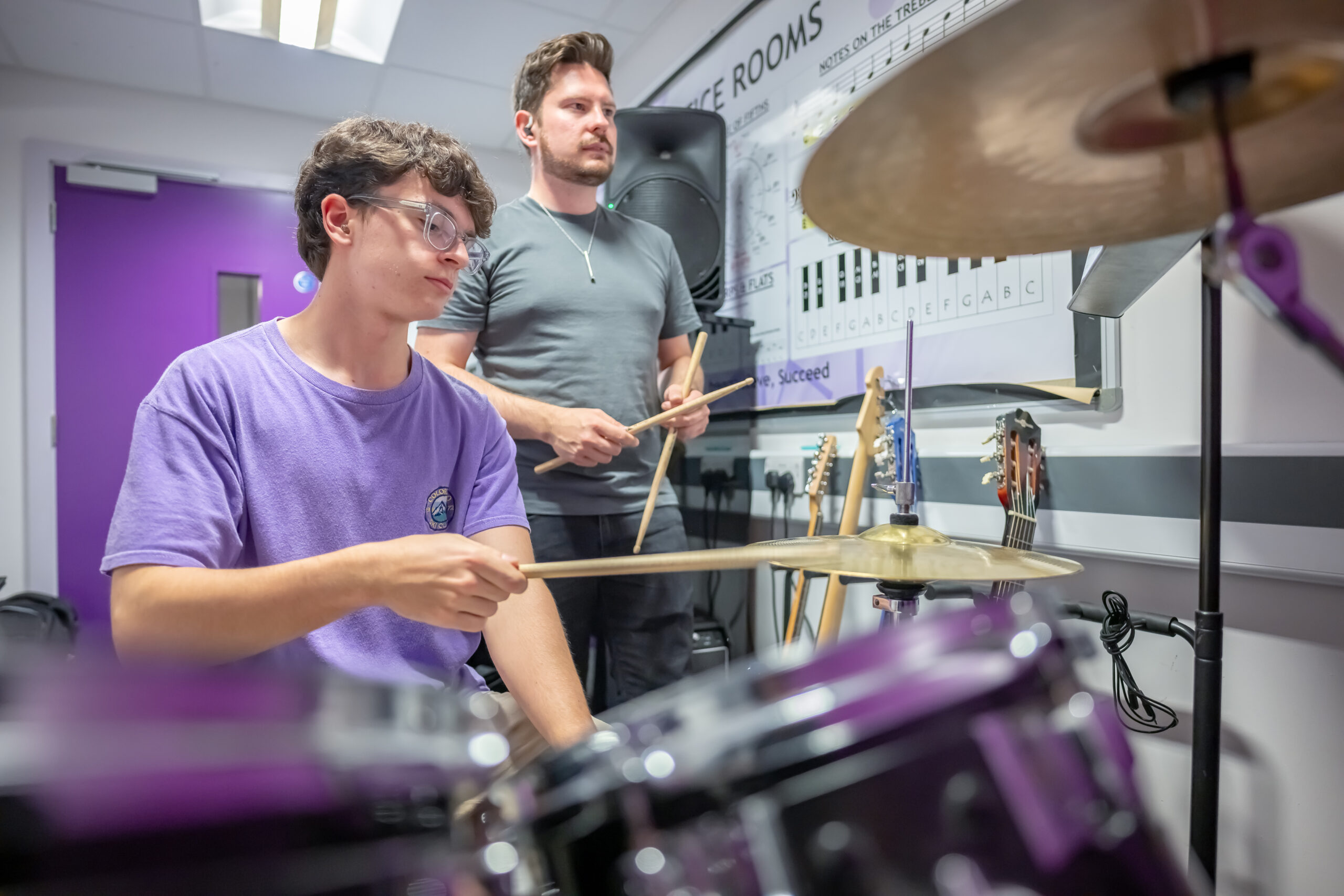 A boy in a MAPAS drum kit lesson
