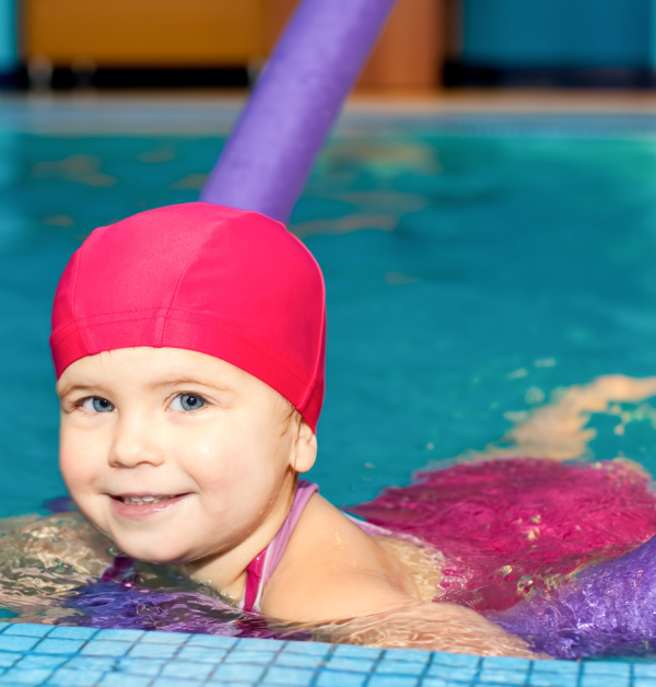 Girl with pink swimming hat and float in pool