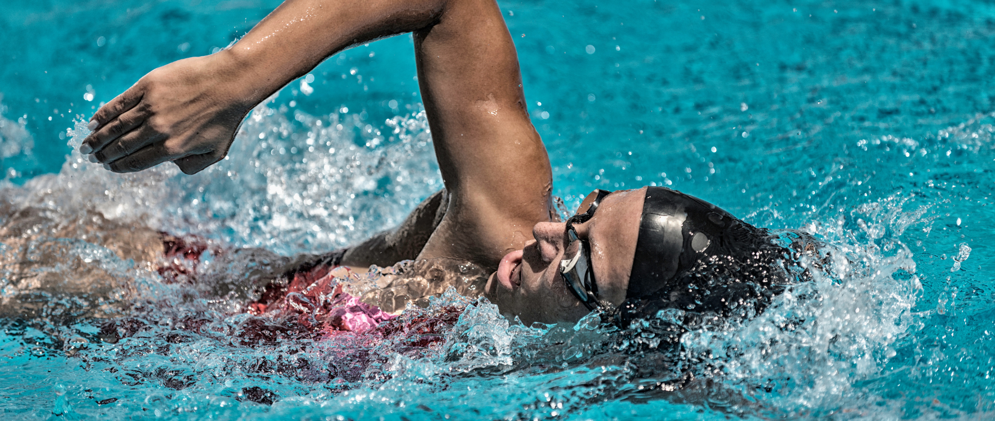 Person swimming with hat and goggles