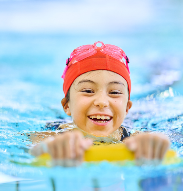Young child swimming in pool with float