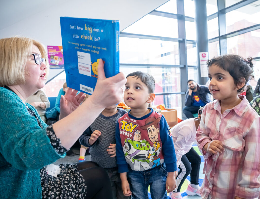 Children engaging with the storytime facilitator at Salford Libraries Books and Rhymes