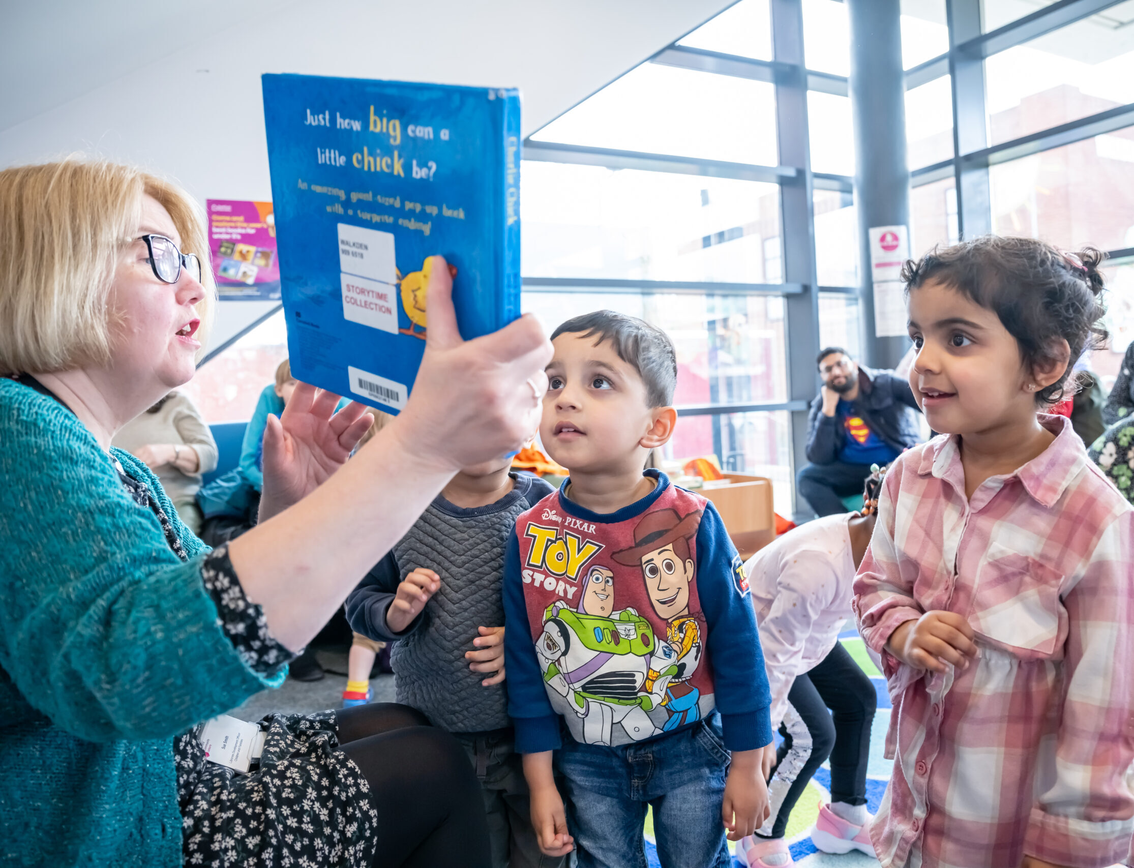 Children engaging with the storytime facilitator at Salford Libraries Books and Rhymes