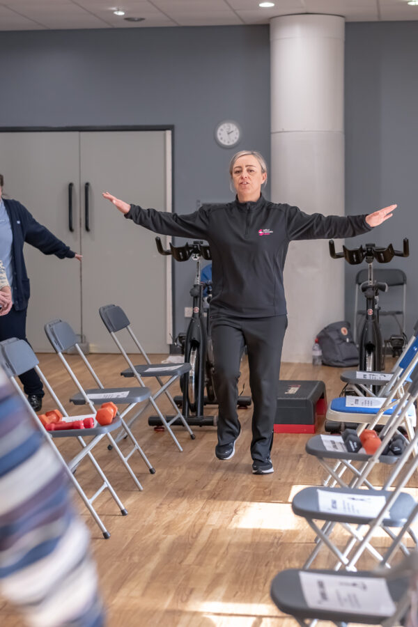 Active lifestyles worker showing a class of people a light exercise
