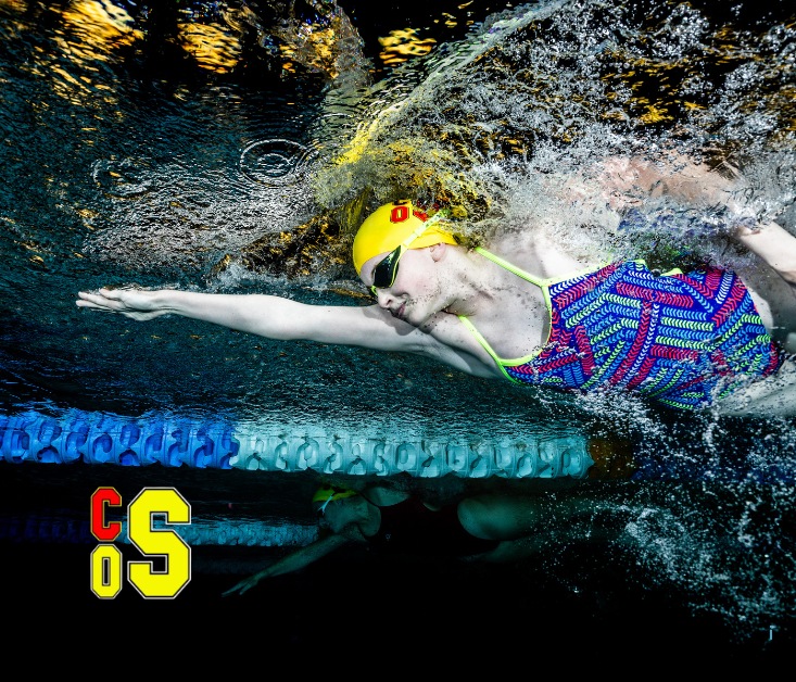 Person swimming underwater with yellow cap