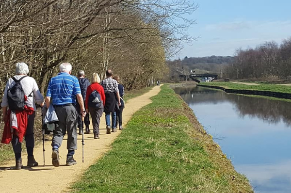 People walking along a canal on a Salford Wellbeing Walk
