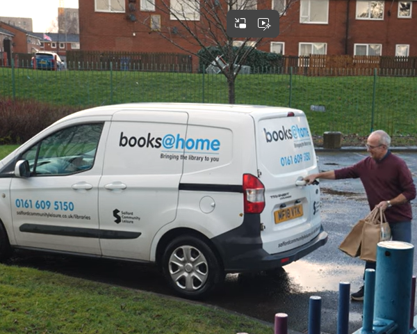 Library worker putting books in the books at home van
