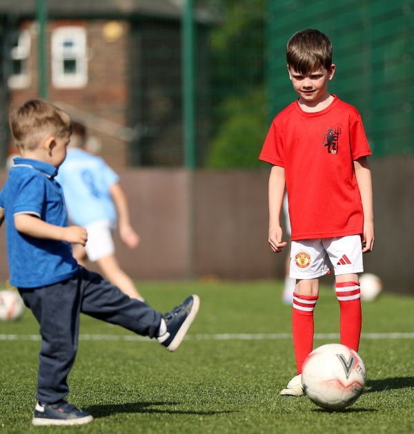 Children playing football during coaching session