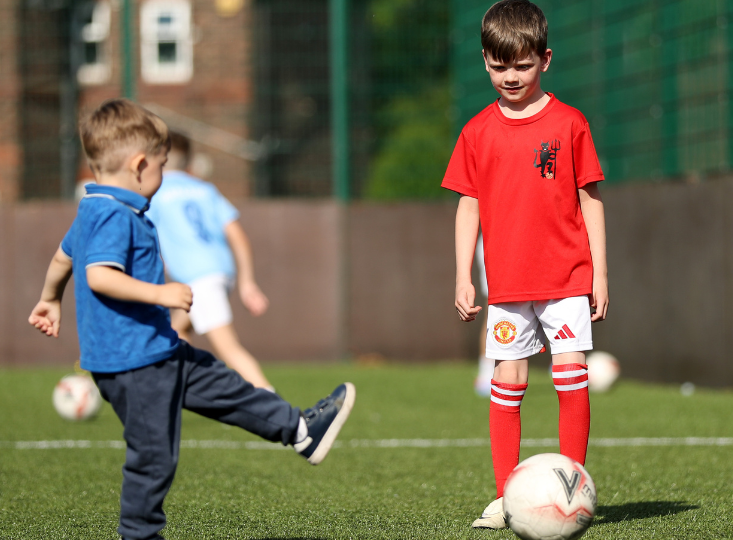 Children playing football during coaching session