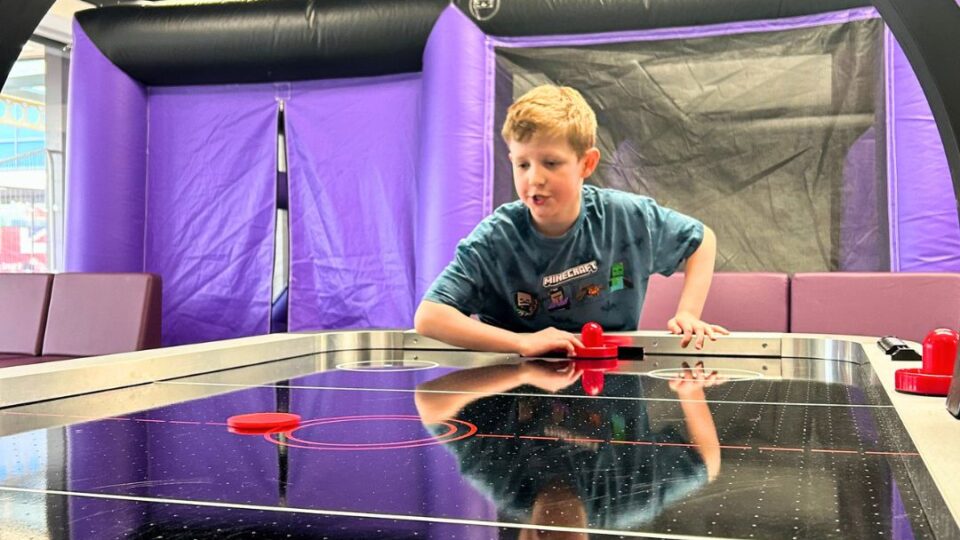 A boy plays air hockey at The Den opening day in Walkden