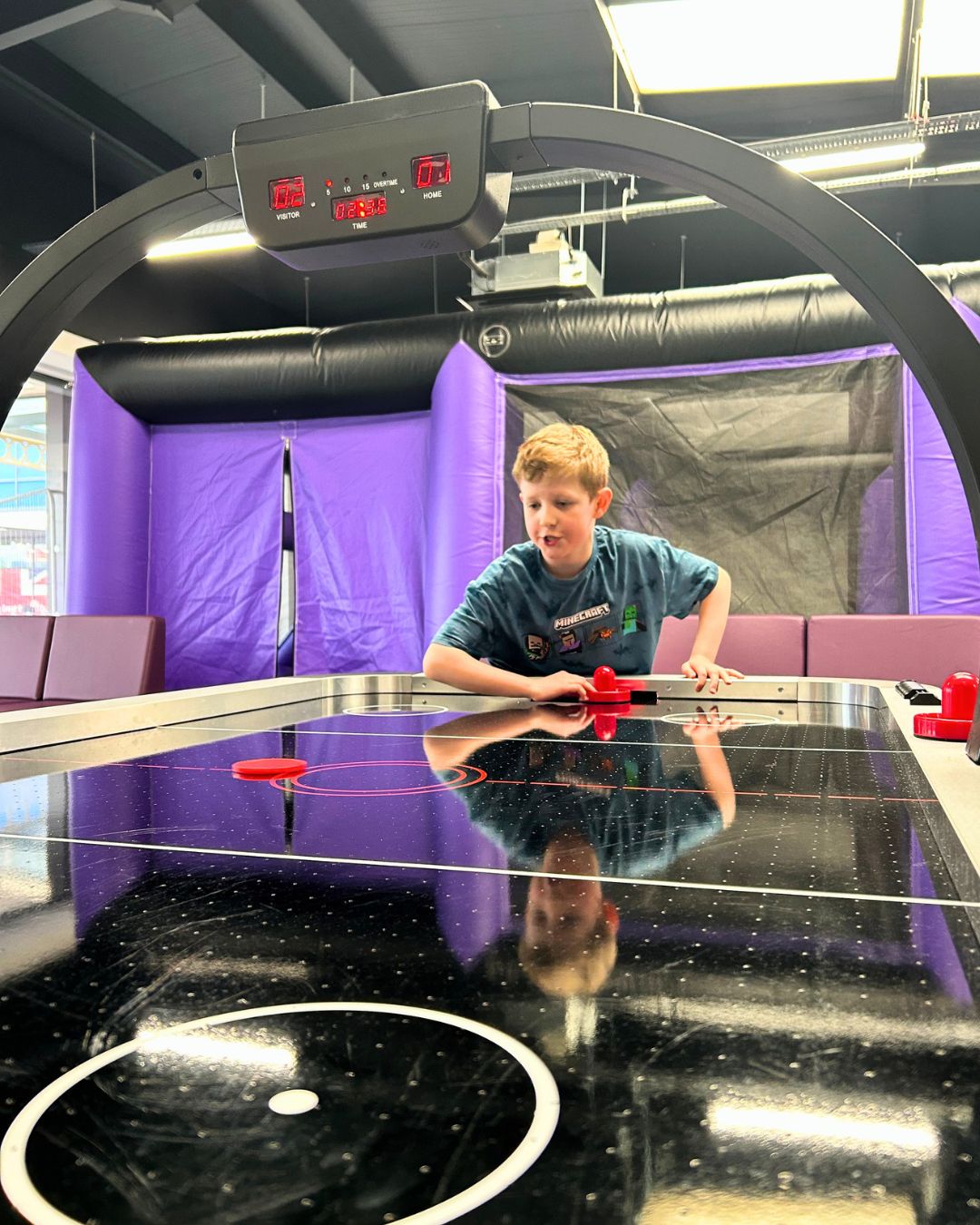 A boy plays air hockey at The Den opening day in Walkden