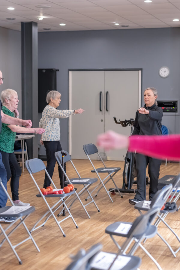 A group of older people taking part in an exercise on referral class with an active lifestyles worker