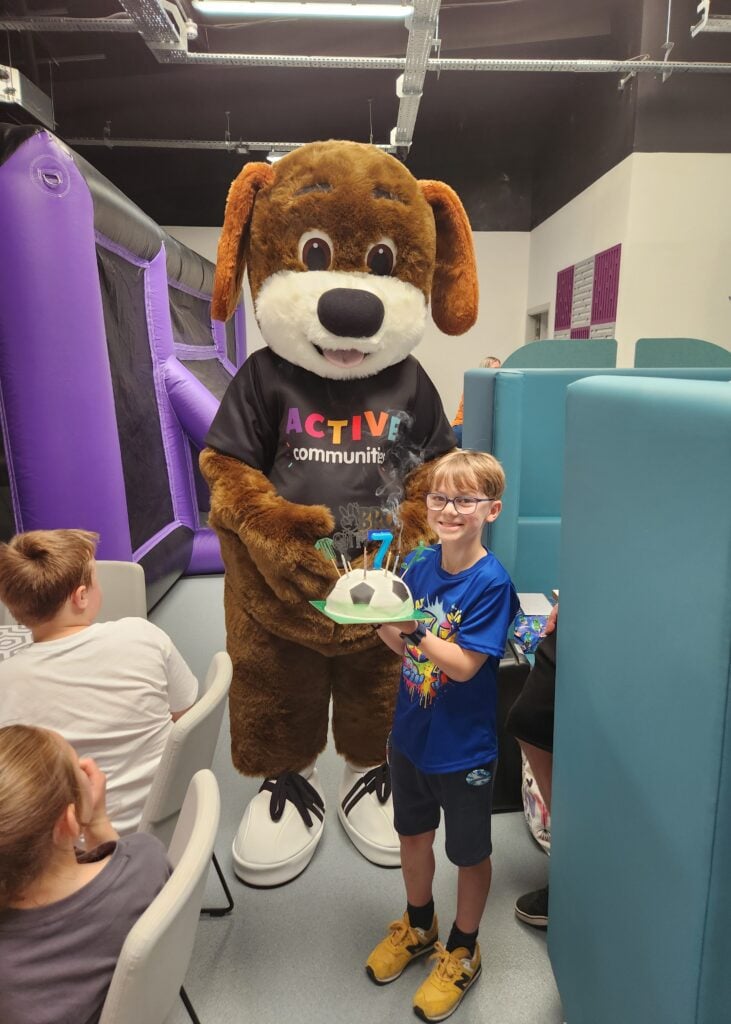 A child with a birthday cake at a birthday party at the den