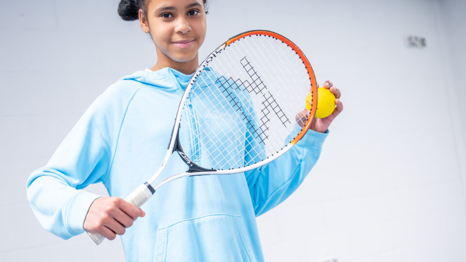 Girl with tennis racquet and ball
