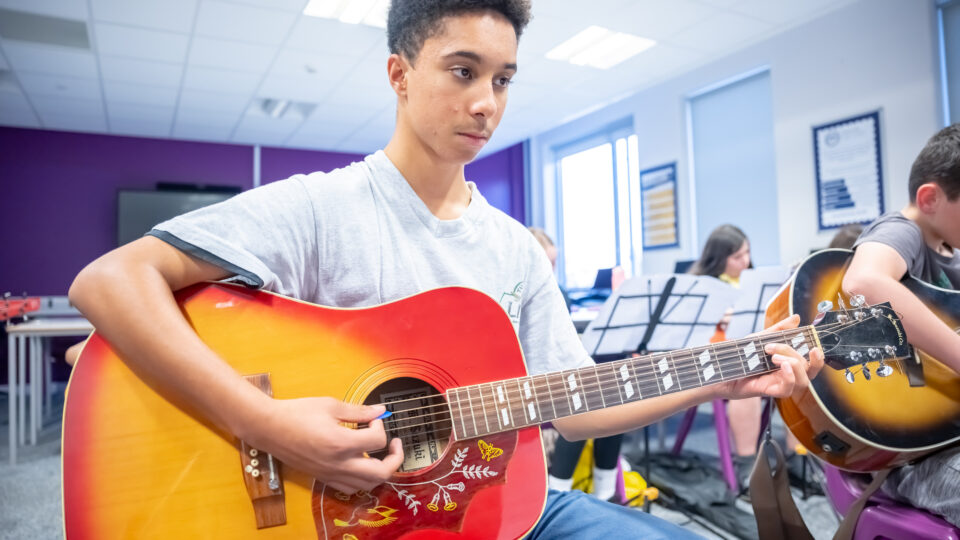 Boy playing a guitar, credit Nick Harrison