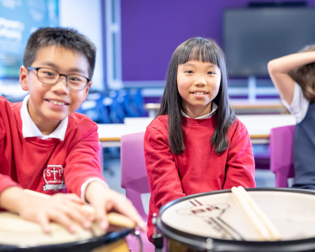 Two children smiling with drums, credit Nick Harrison