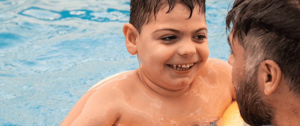 Child in pool with man