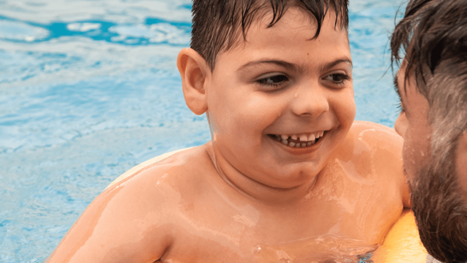 Child in pool with man