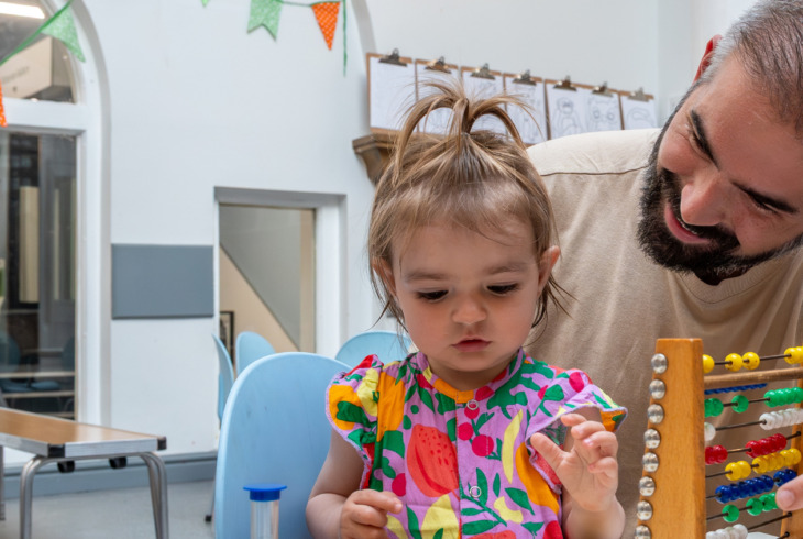 Man and young child playing with toys