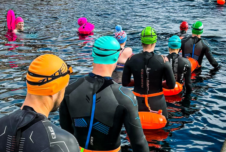 People entering water for open water swimming session